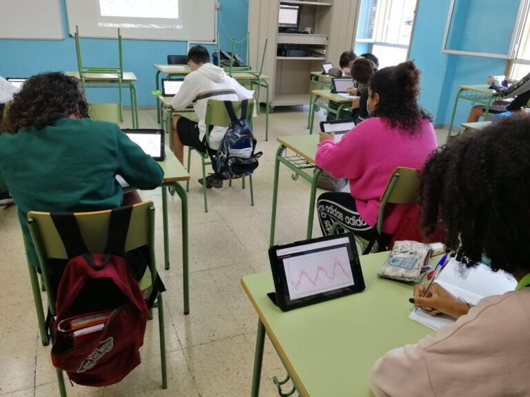 Estudiantes en clase analizando curvas de luz de estrellas variables en tablets