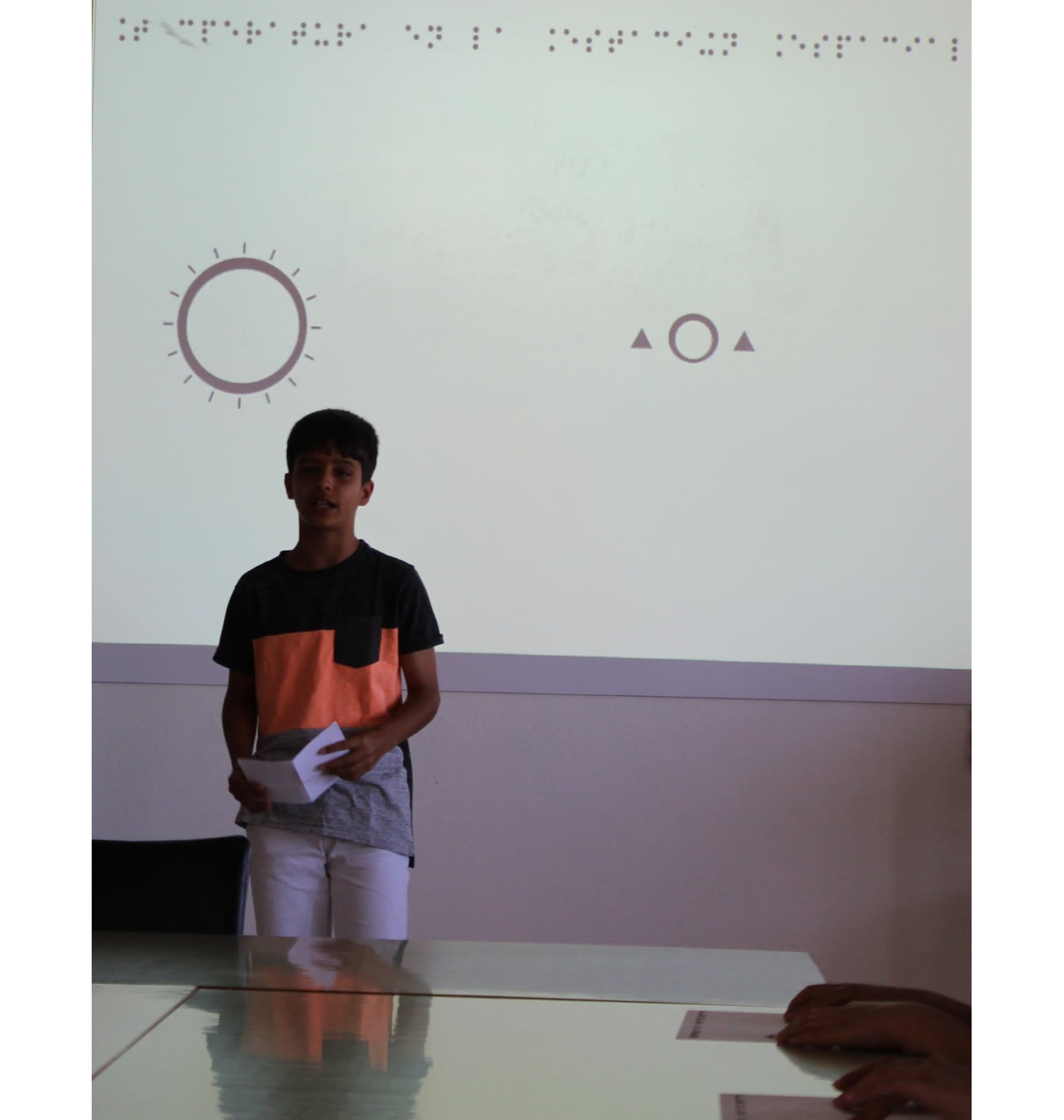 Rocha21 explica el experimento de temperatura con diagrama táctil y braille Integrante del equipo Rocha21 del IES José Frugoni Pérez explica su experimento de temperatura, con diagrama táctil y texto en braille, a alumnado con discapacidad visual