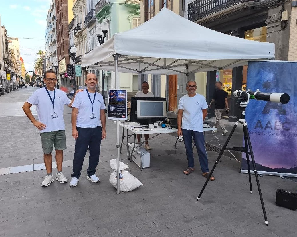 Cuatro miembros de la AAEC junto a la carpa, el telescopio solar y el cartel de la campaña en la calle de Triana