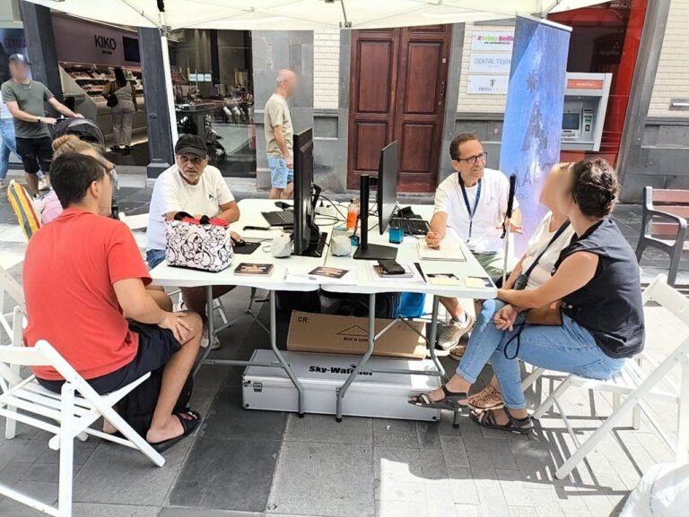 Mesa de talleres con una pareja en la búsqueda de asteroides y una familia conociendo diagramas táctiles