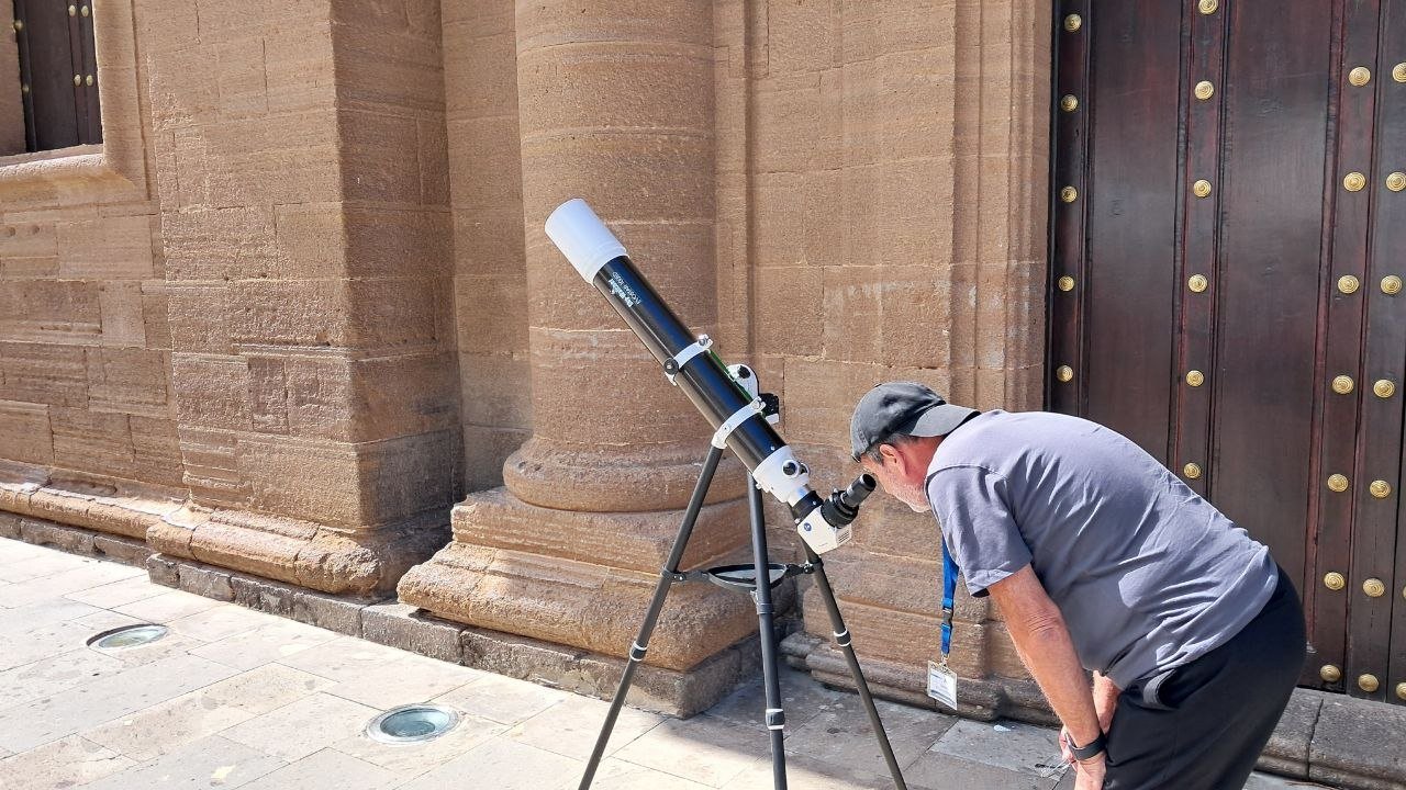 Persona observando el Sol con un telescopio junto a la iglesia de Santiago de Gáldar, en la edición de 2025